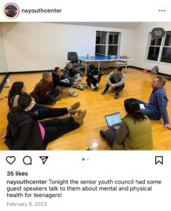 Screenshot of Instagram post by "nayouthcenter." Photo of young people sitting on the floor in a circle with ϲ facilitator. Caption: "tonight the senior youth council had some guest speakers talk to them about mental and physical health for teenagers!" Dated February 8, 2023.